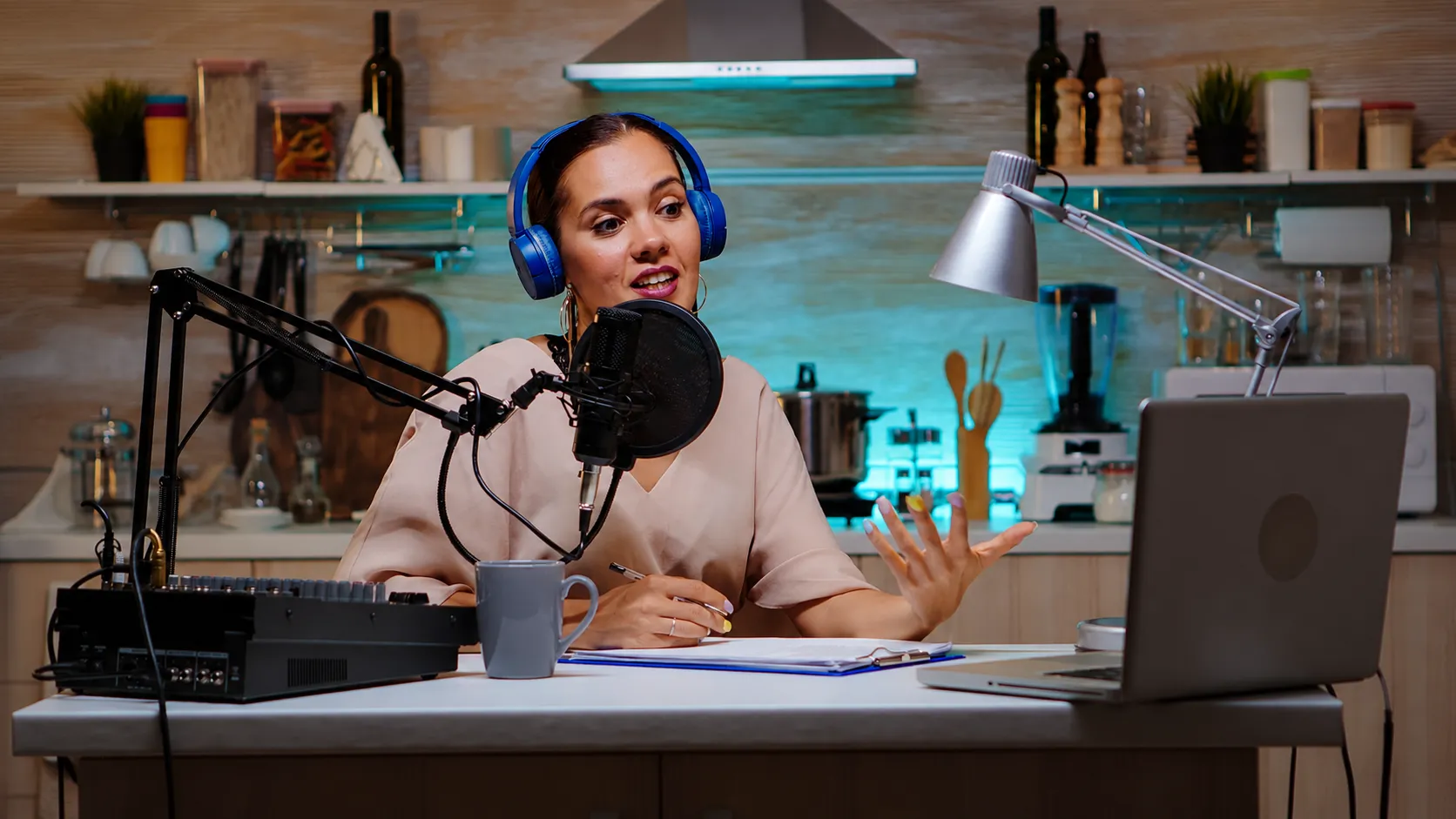 A person typing on a laptop with a glowing microphone icon and dual-tone audio waveforms behind, representing scene-level multi-language dubbing